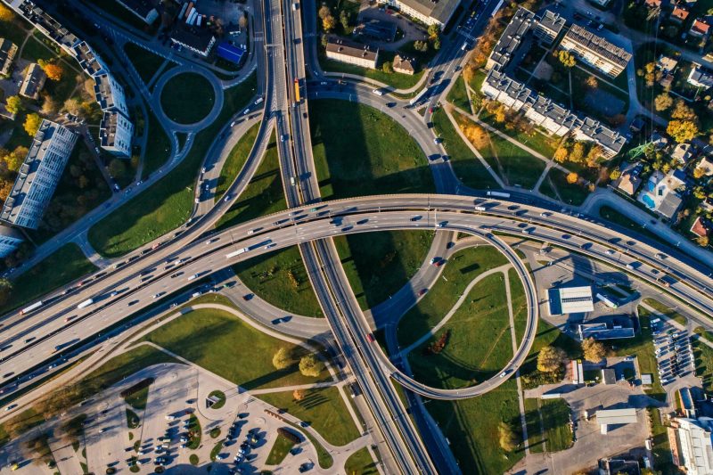 Aerial shot of a complex highway intersection in a vibrant urban cityscape.